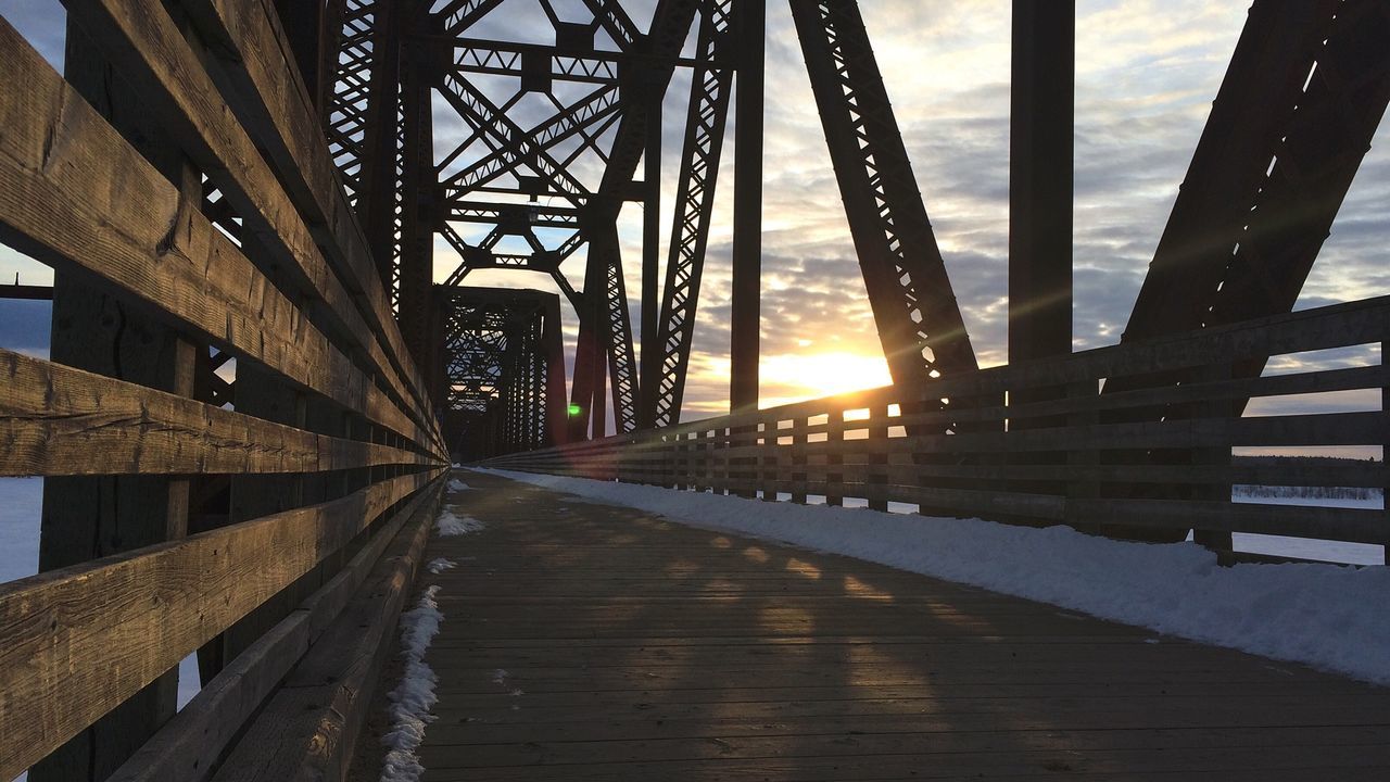 Cantilever footbridge with snow against sky