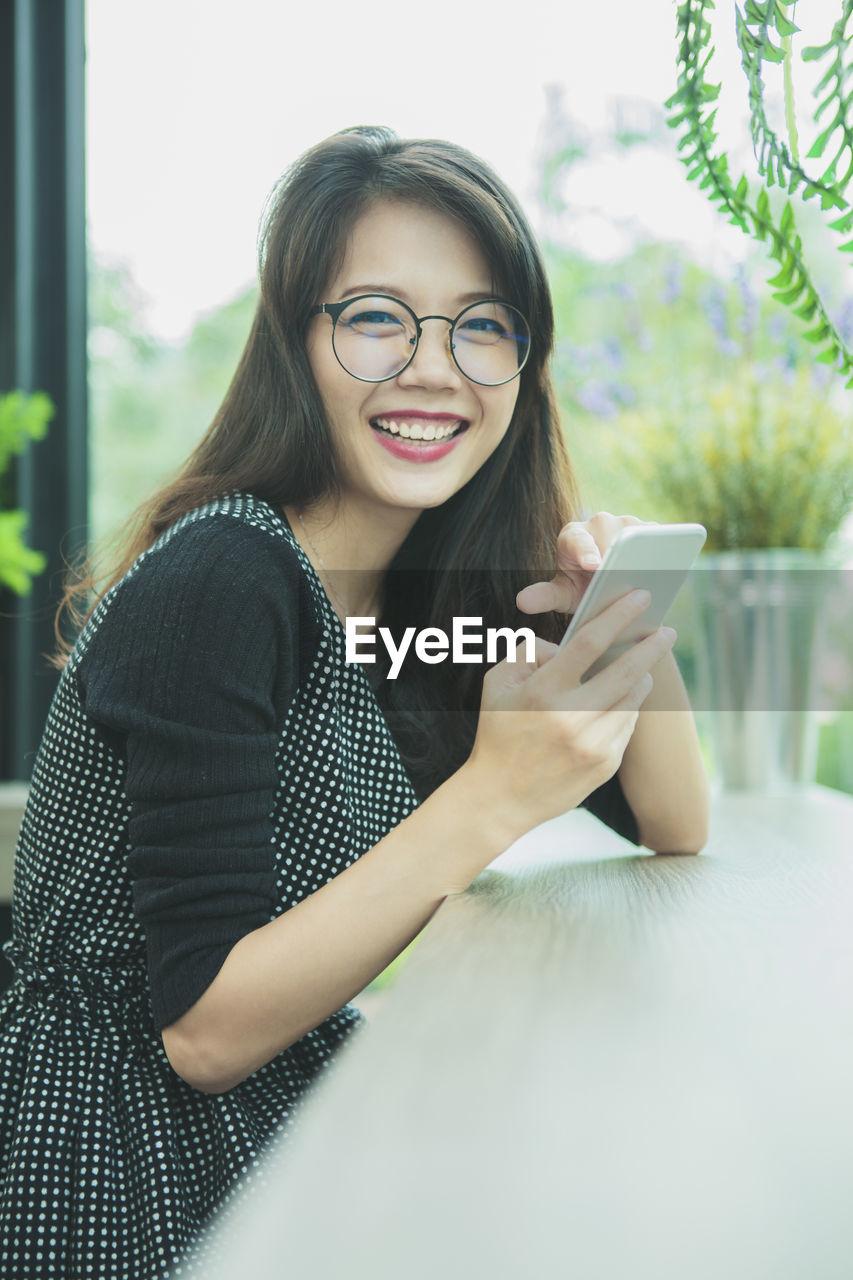 Asian younger woman laughing with happiness emotion reading smart phone