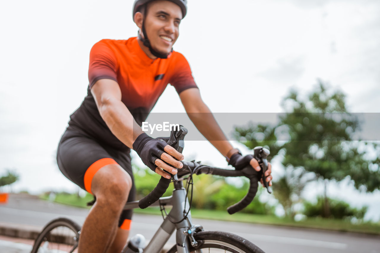 low angle view of man riding bicycle on street