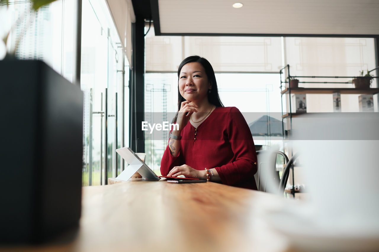 Portrait of businesswoman with digital tablet at coffee shop