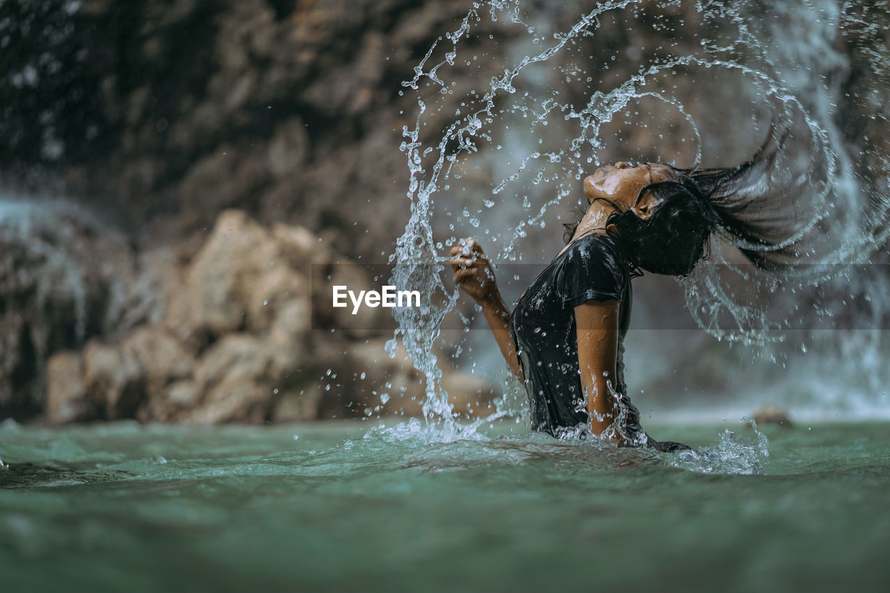 Midsection of woman splashing water