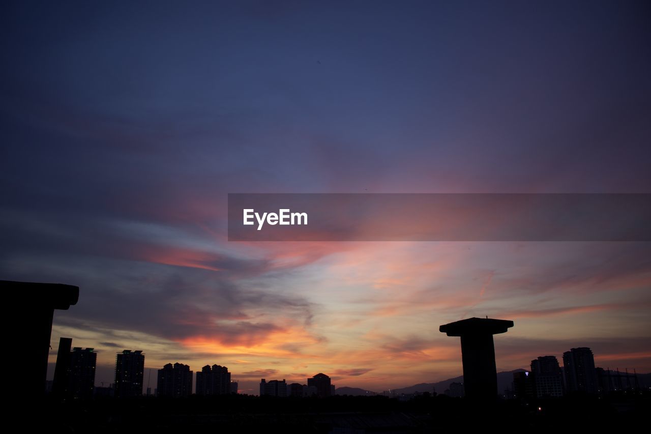 Silhouette buildings against sky during sunset