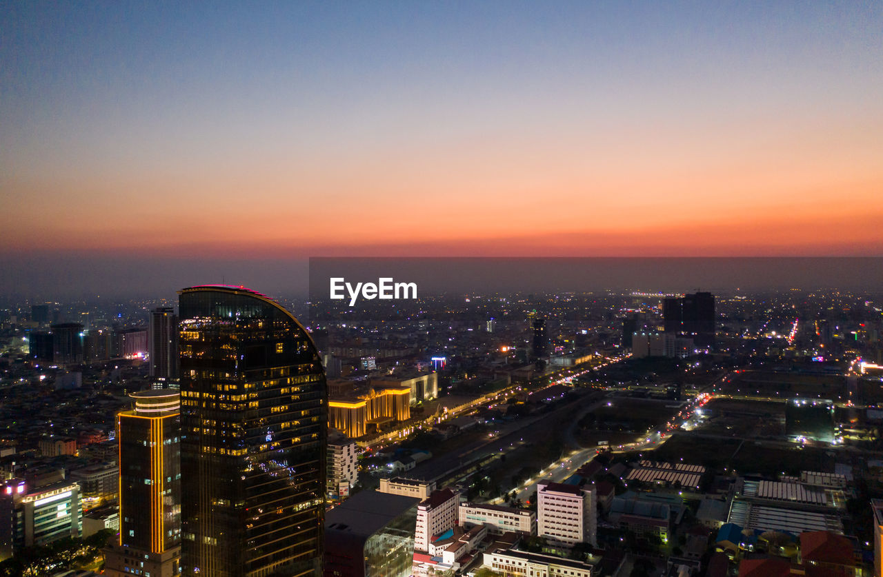 High angle view of illuminated buildings against sky at night