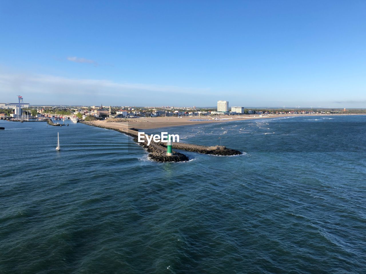 Scenic view of sea and buildings against blue sky