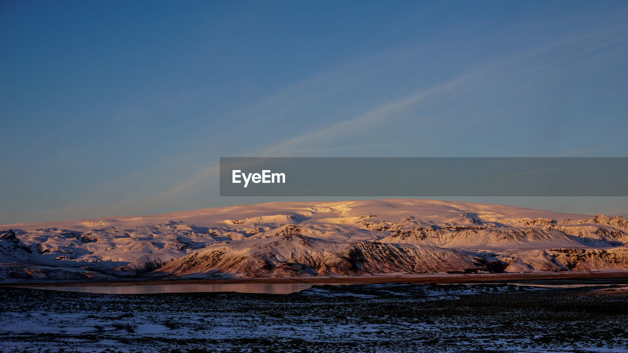 Scenic view of snowcapped mountains against sky during sunset