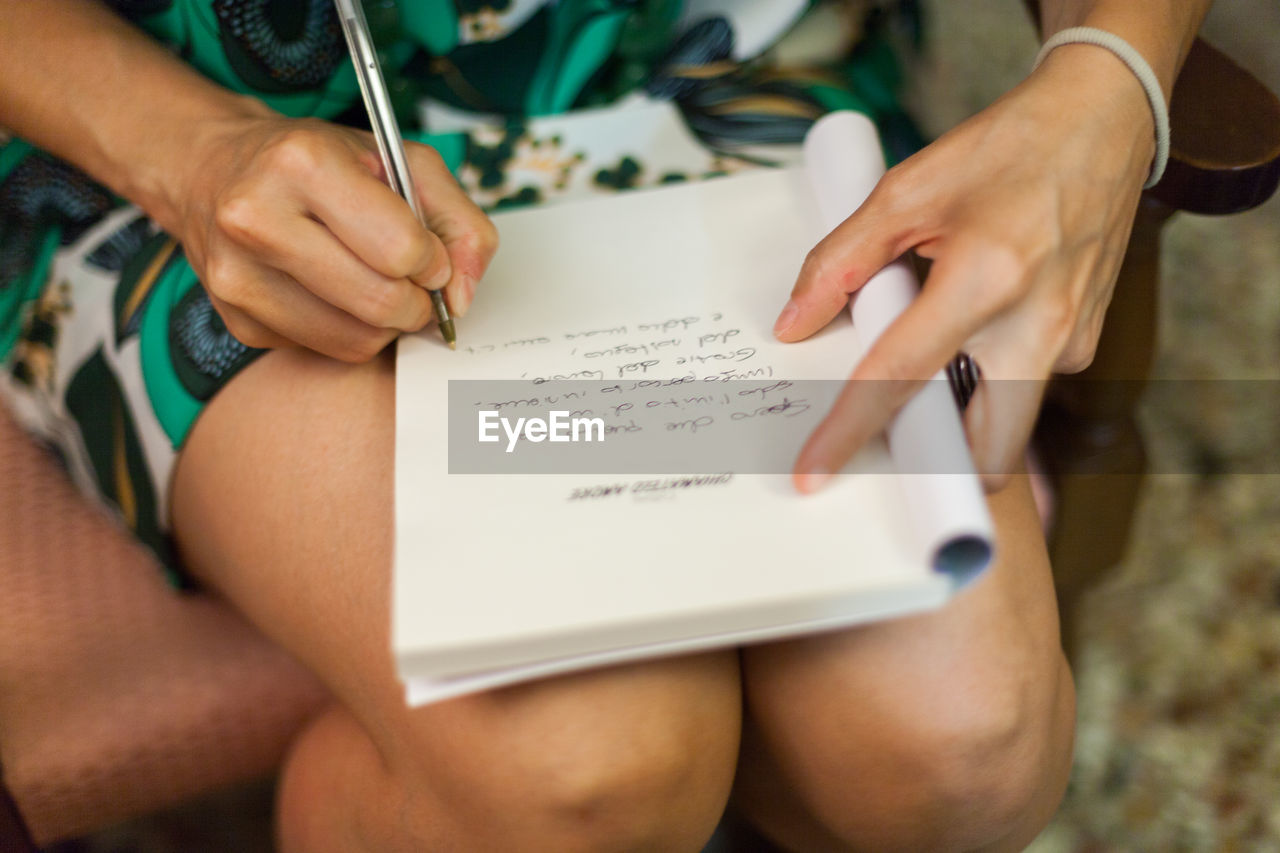 Close-up of woman writing notes