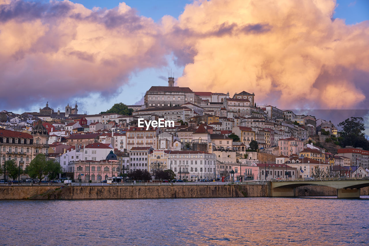 Coimbra city view at sunset with mondego river and beautiful historic buildings, in portugal