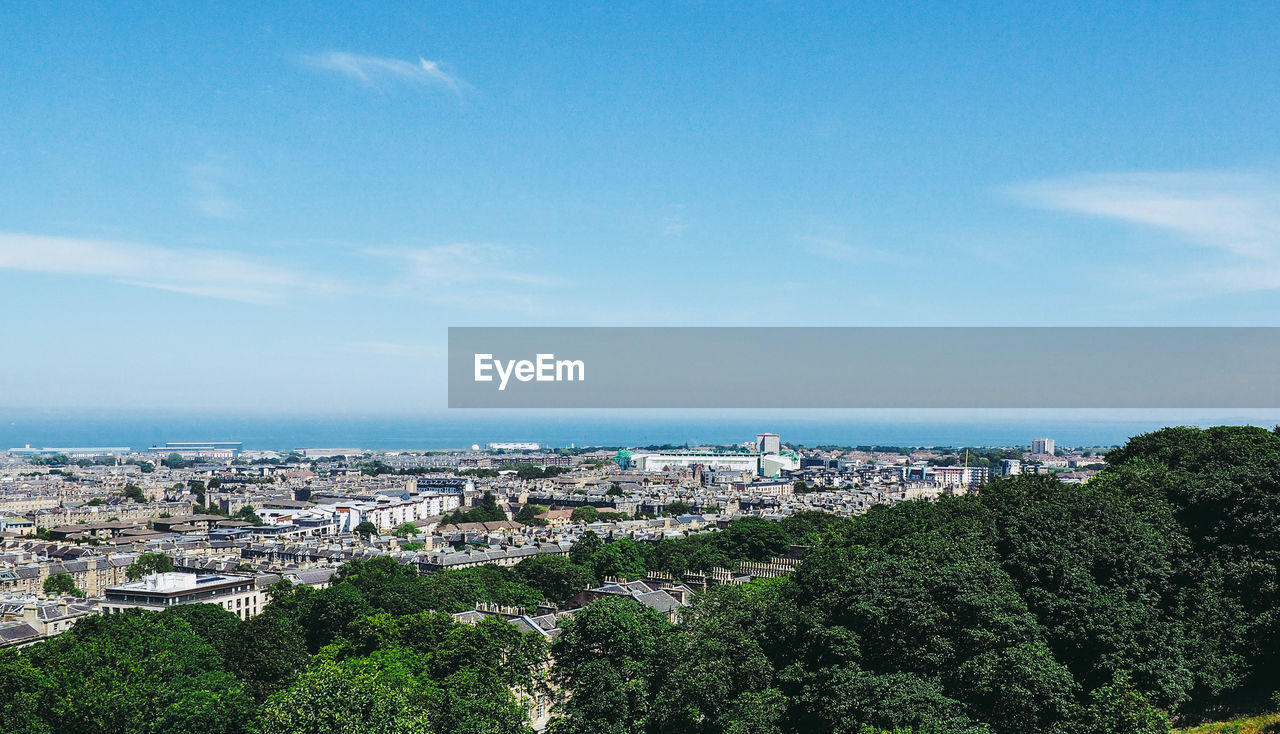 Aerial view of townscape by sea against sky