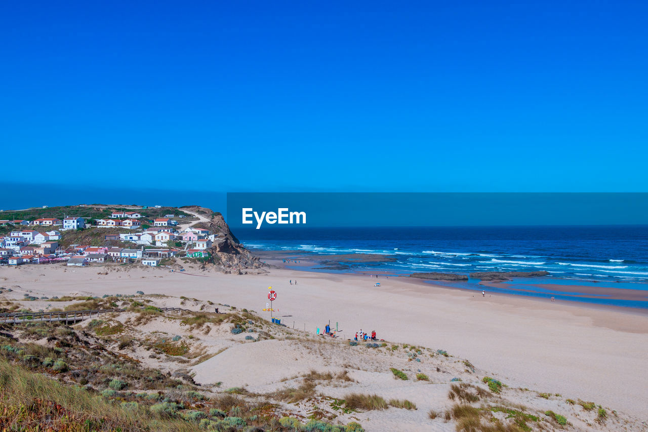 Scenic view of beach against clear blue sky