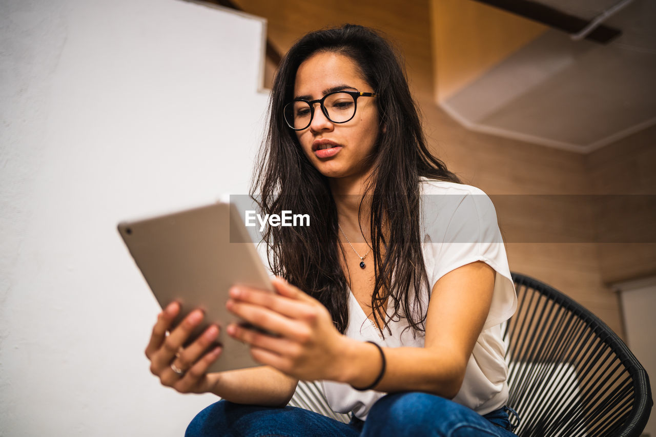 Low angle view of woman using digital tablet