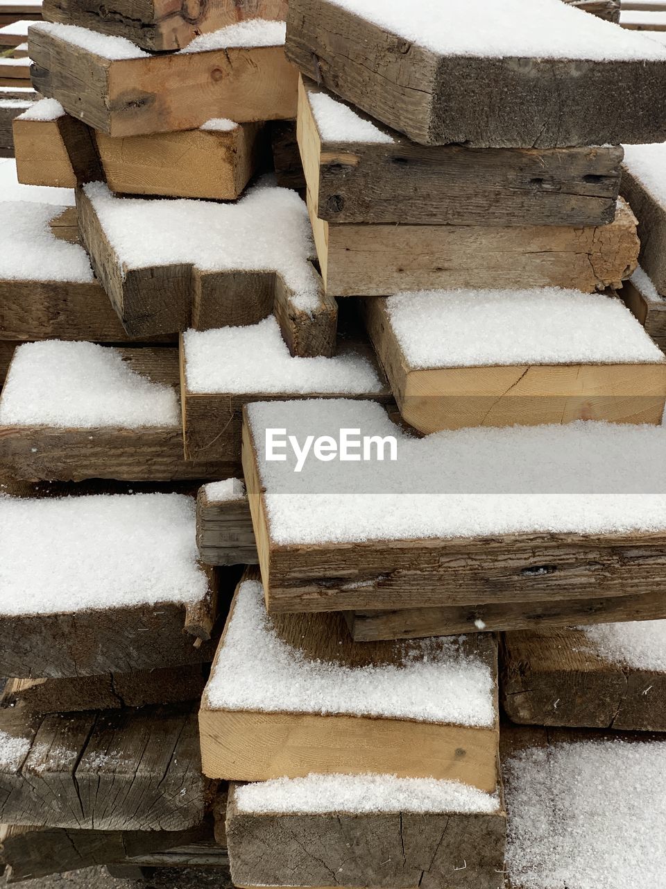 FULL FRAME SHOT OF WOODEN LOGS IN WINTER