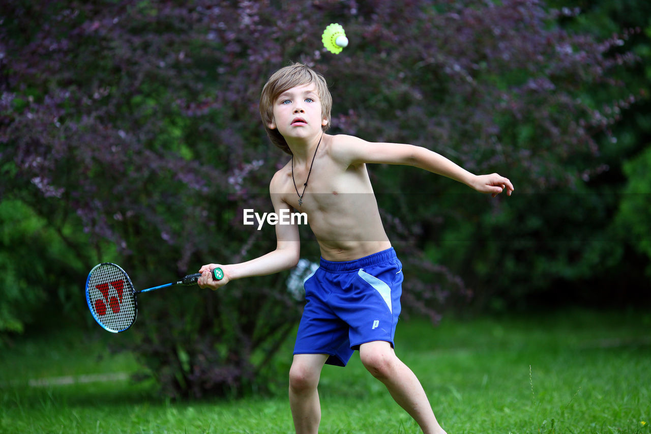 A 7 year old boy plays badminton.