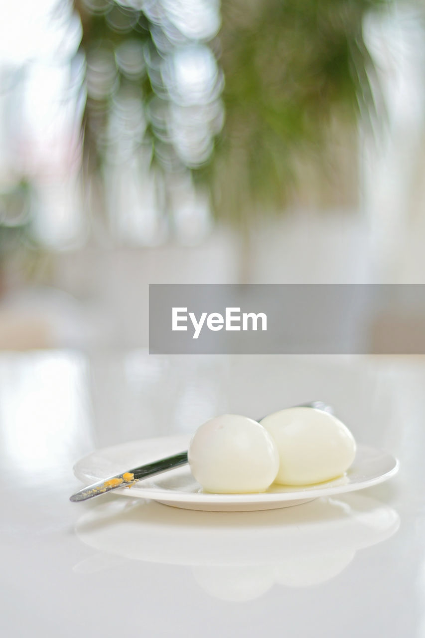 Boiled eggs on a kitchen table, healthy protein rich breakfast. plate, a knife, white background.