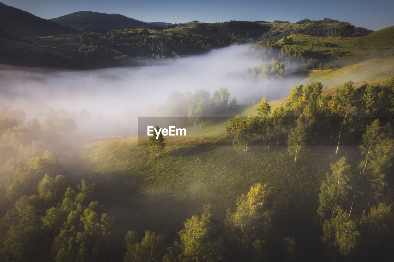 View from drone of incredible atmosphere with foggy hills at sunrise. 