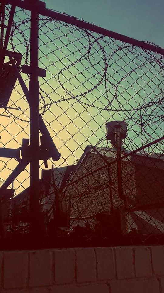 LOW ANGLE VIEW OF CHAINLINK FENCE AGAINST SKY