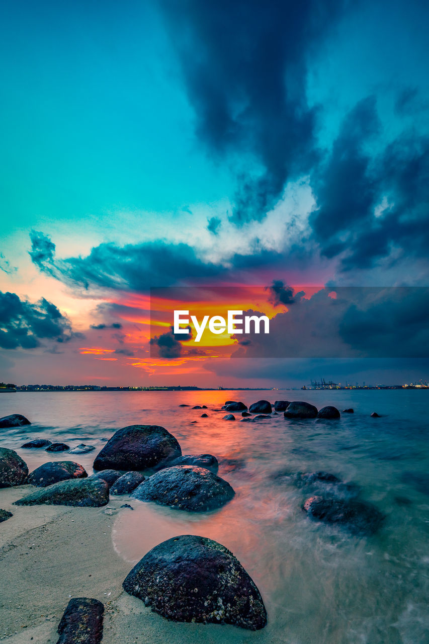 SCENIC VIEW OF BEACH AGAINST SKY DURING SUNSET