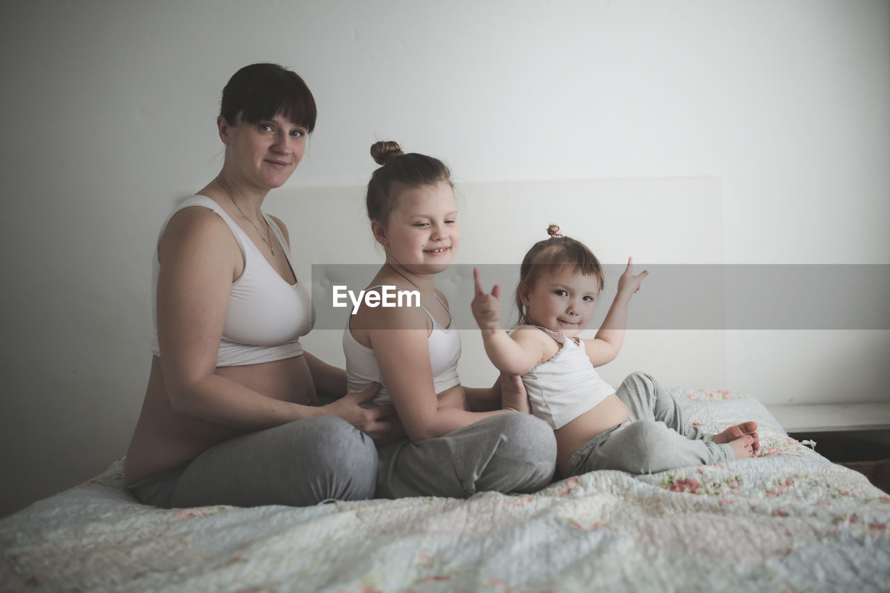 Pregnant mother with daughters, life style in a real interior. the concept of large families 