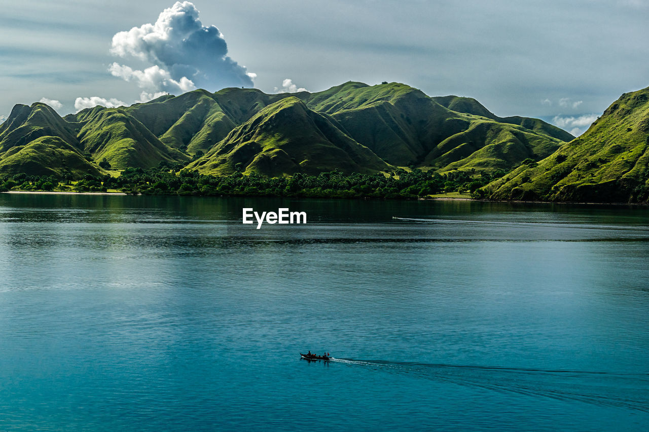 Scenic view of lake by mountains against sky