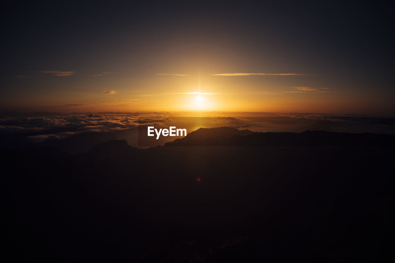 SCENIC VIEW OF SUNSET OVER MOUNTAINS