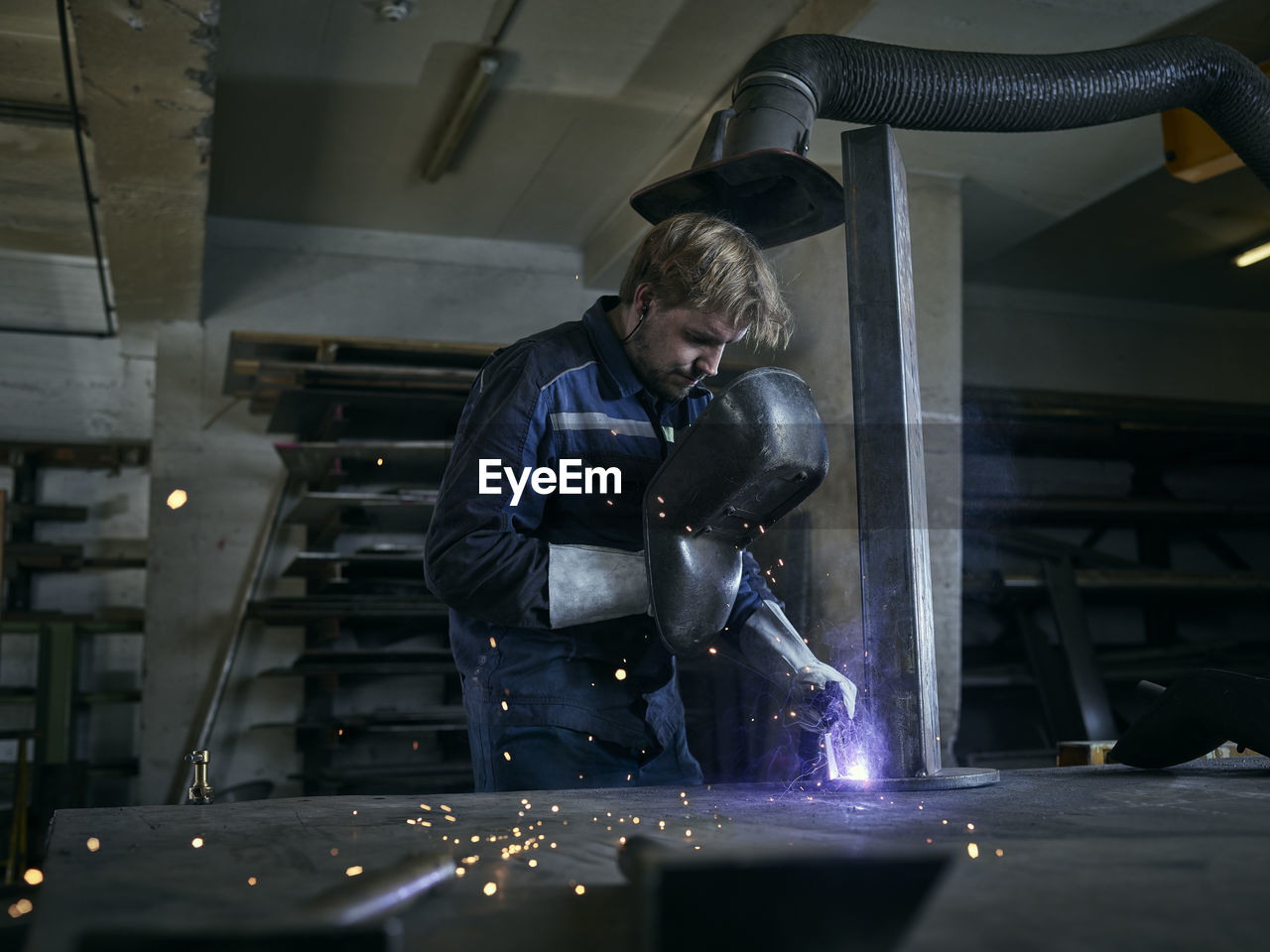 Worker welding in factory