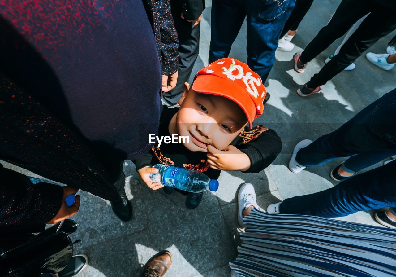 HIGH ANGLE VIEW OF BOY STANDING ON CAR