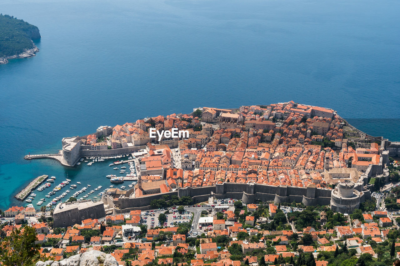 High angle view of town by sea against sky