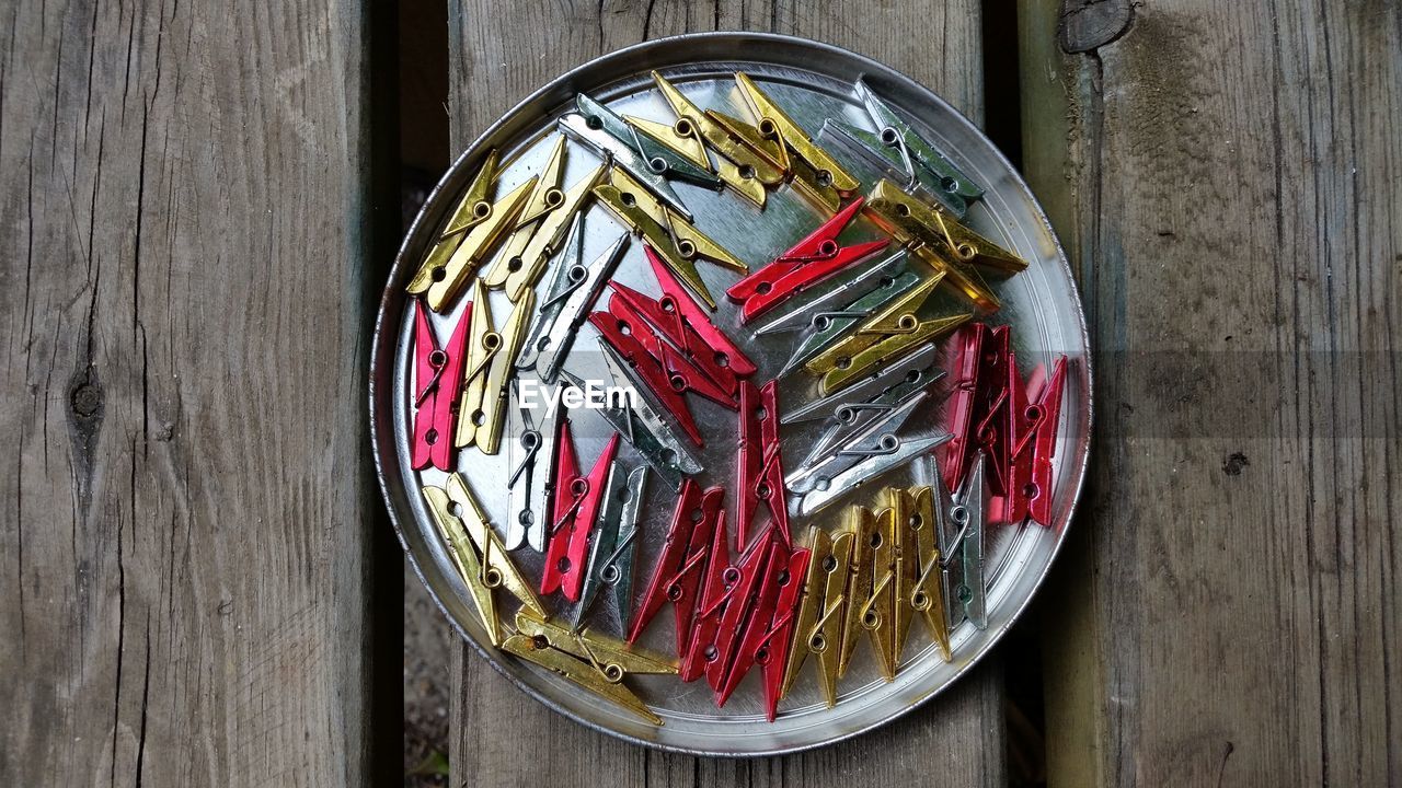 Directly above shot of clothespin on plate on wooden table