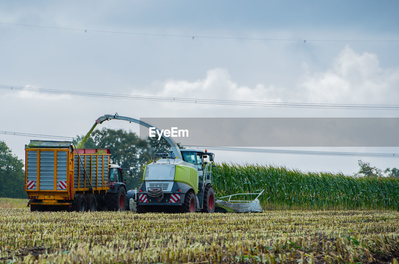 Agricultural machinery on field against sky