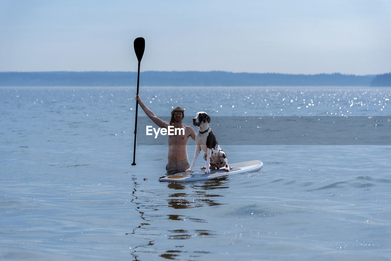 High angle view of woman photographing sea against sky
