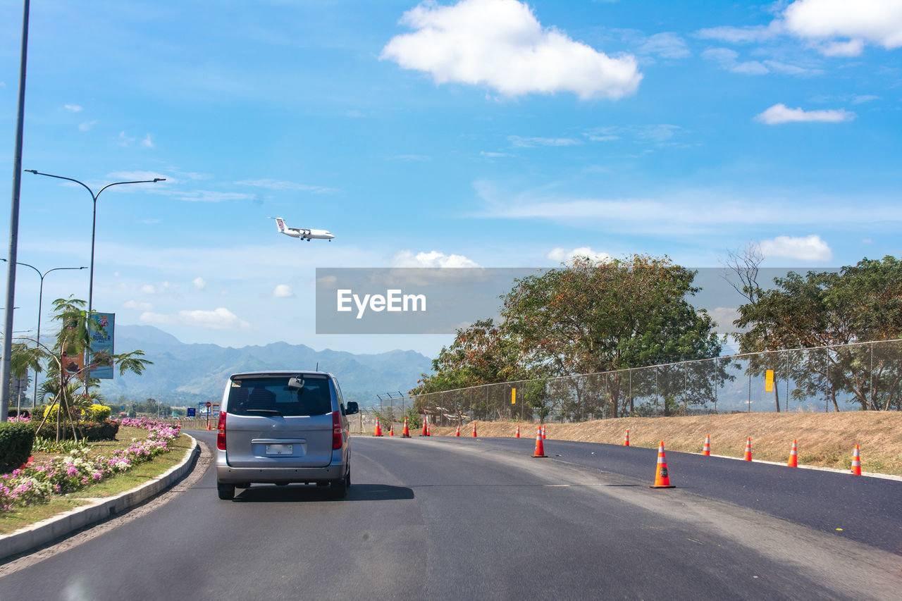 VEHICLES ON ROAD AGAINST SKY