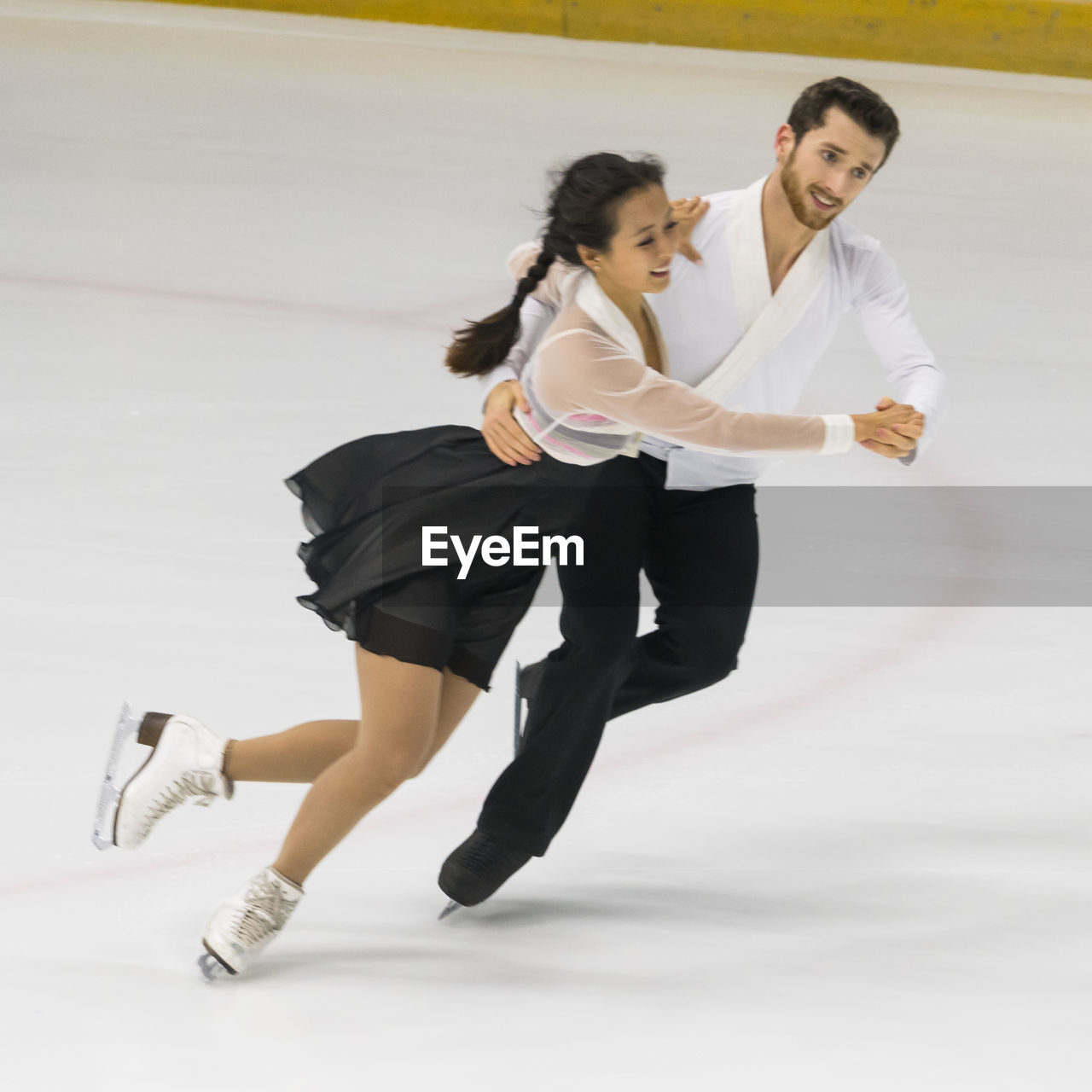 Full length of couple dancing on ice rink