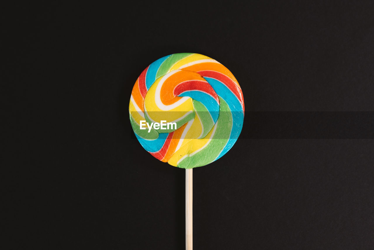 Swirl round lollipop on black background. concept of unhealthy food,sweets and candy day