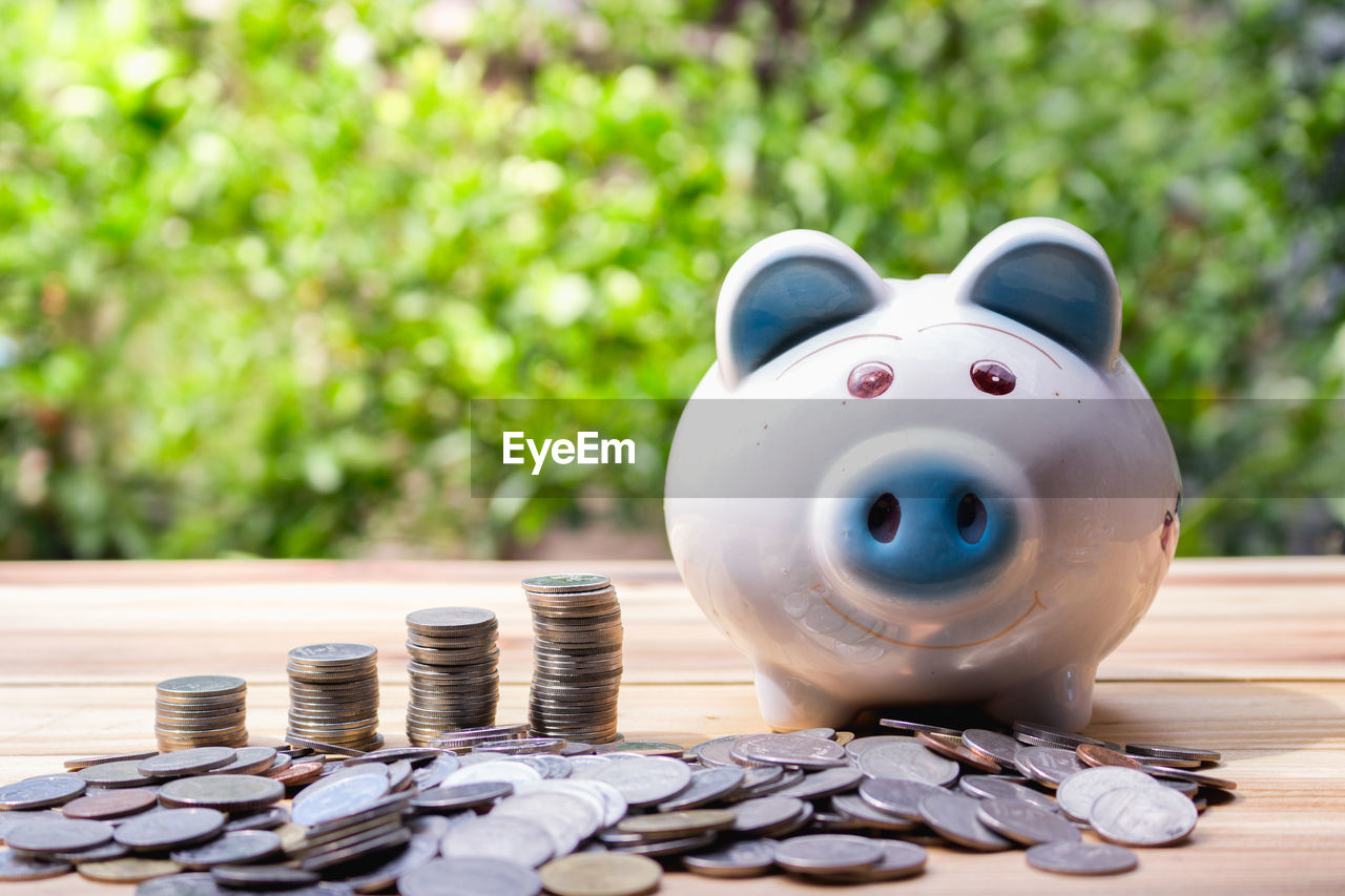 Piggy bank with coins on table