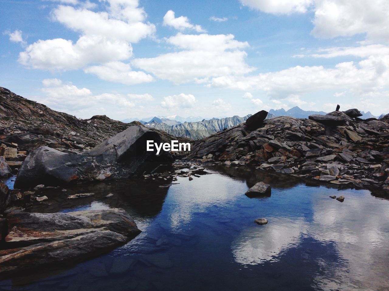 Scenic view of lake by mountains against sky