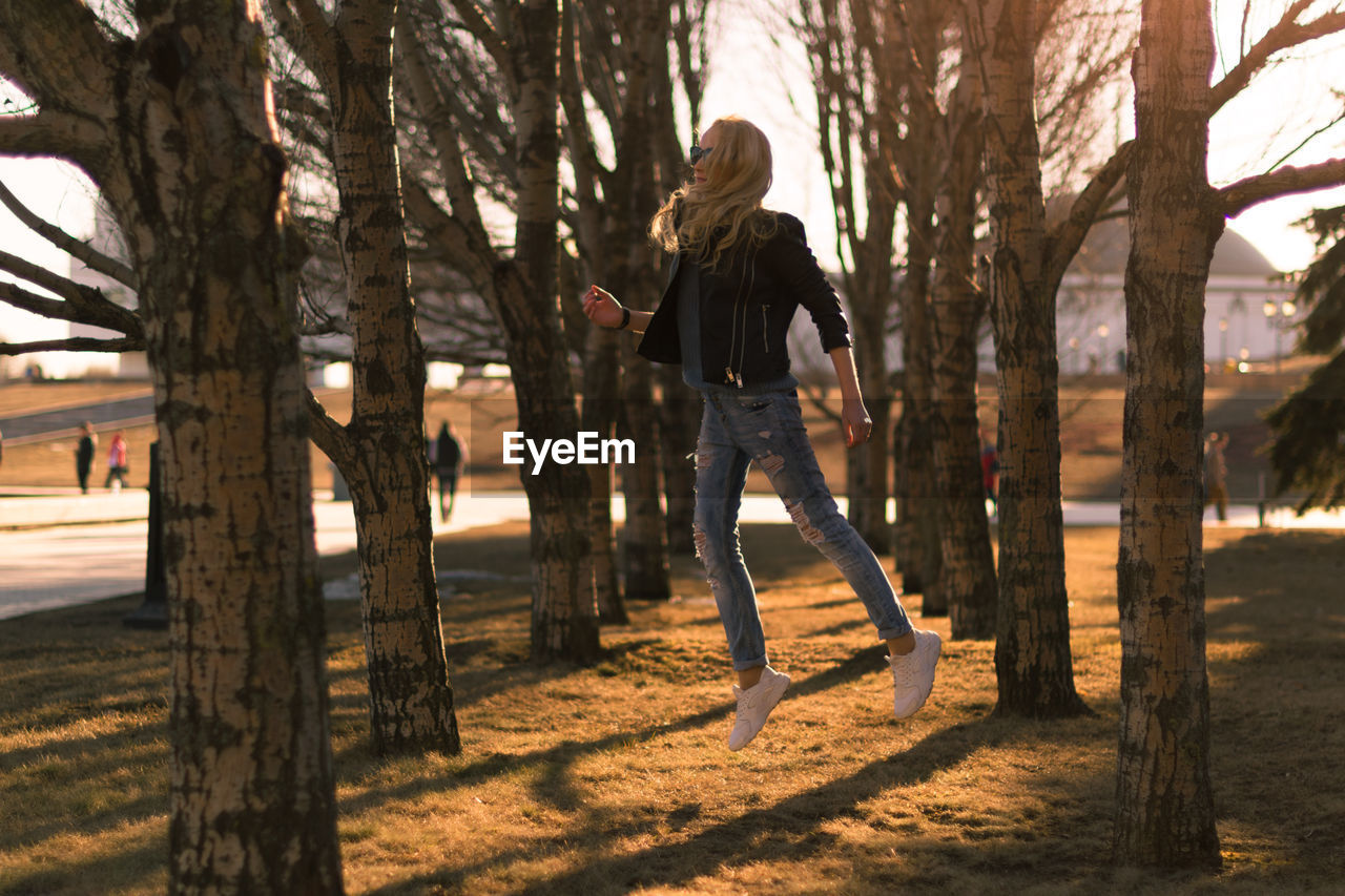 Woman jumping amidst trees