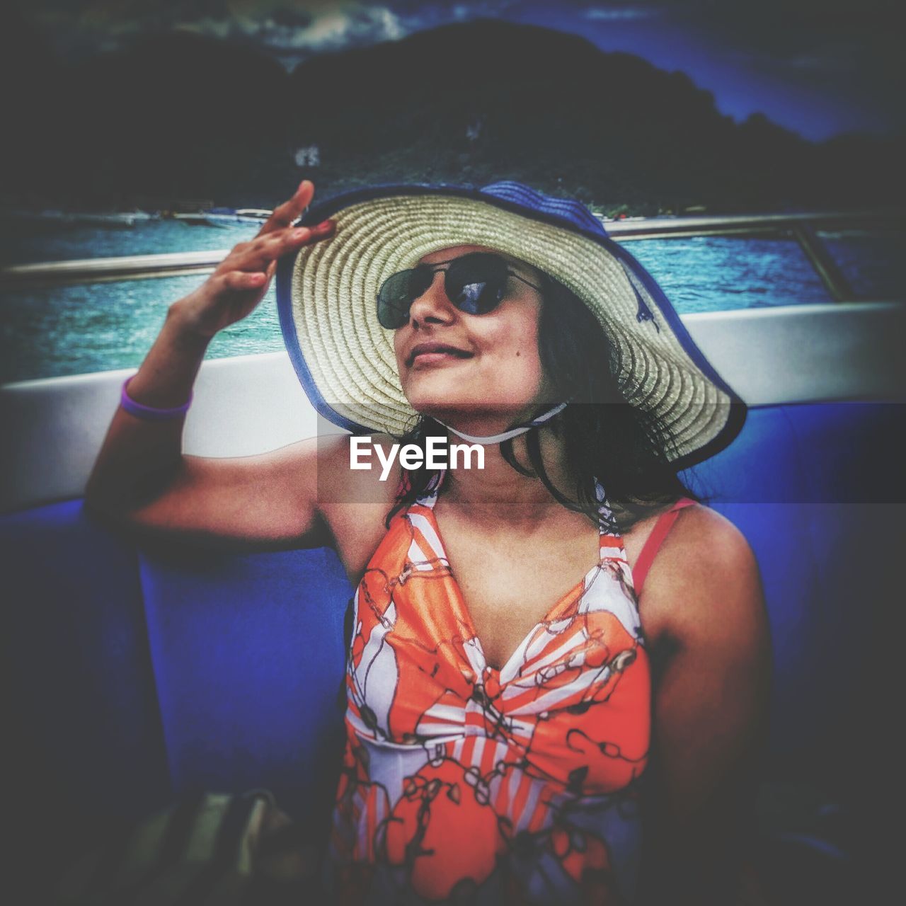 Young woman wearing hat traveling in boat