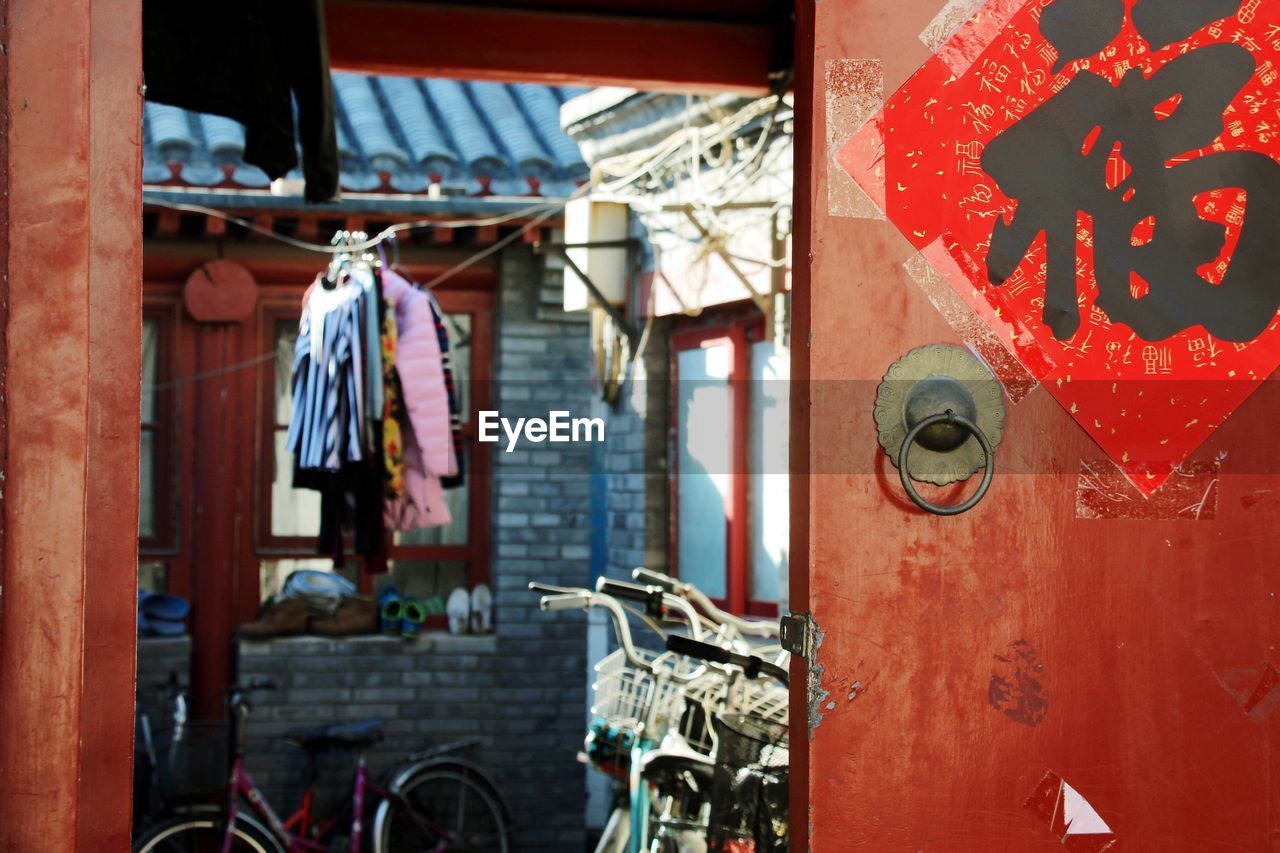Bicycles parked by house seen through gate