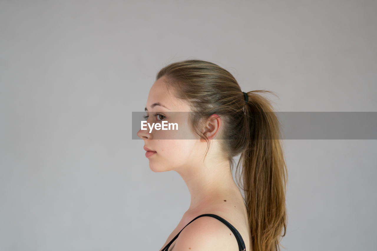 PORTRAIT OF A YOUNG WOMAN OVER WHITE BACKGROUND