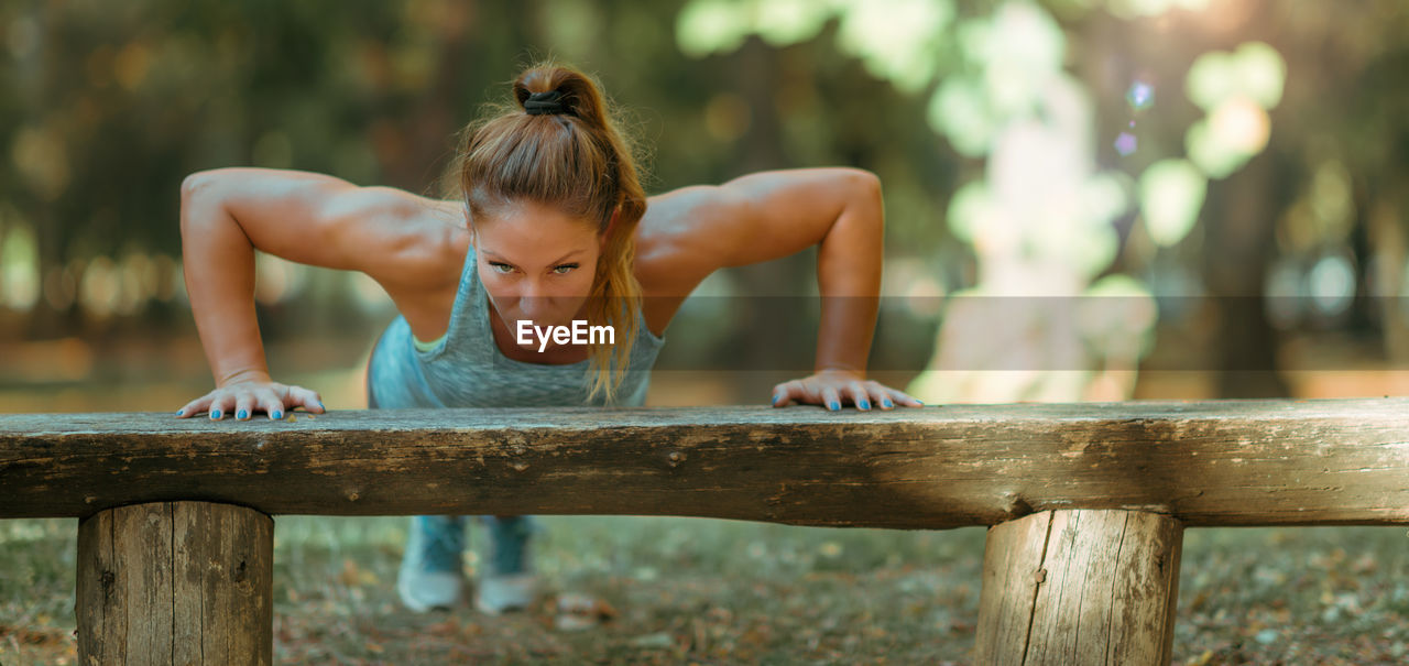 Woman doing push ups in the park, in the fall in public park
