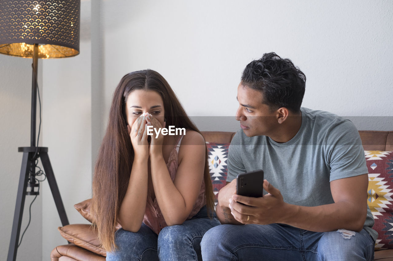 Young couple sitting on mobile phone