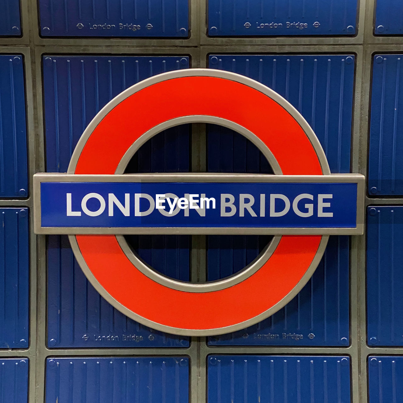 Close-up of london bridge underground sign against blue wall