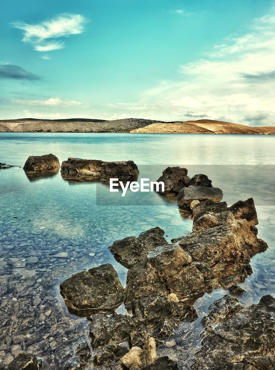 ROCKS ON SHORE AGAINST SKY