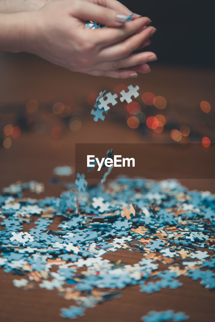Close-up of hand holding puzzle on table