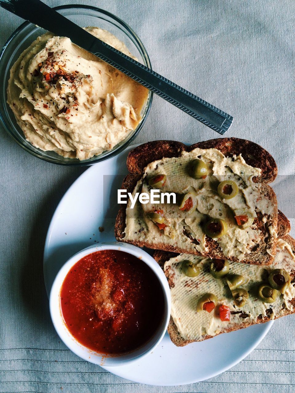 Directly above view of hummus spread and bread served on table