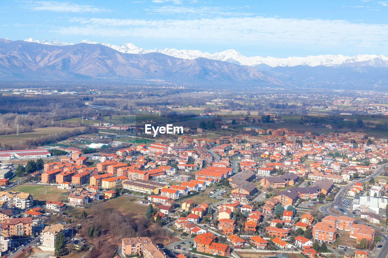 Flying over venaria from metropolitan city of turin . aerial view of turin suburbs and alps mountain
