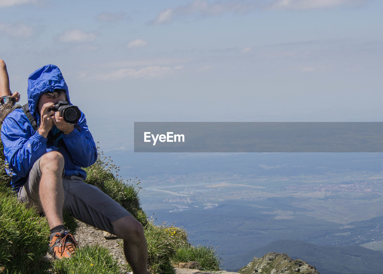 MAN ON MOUNTAIN AGAINST SKY