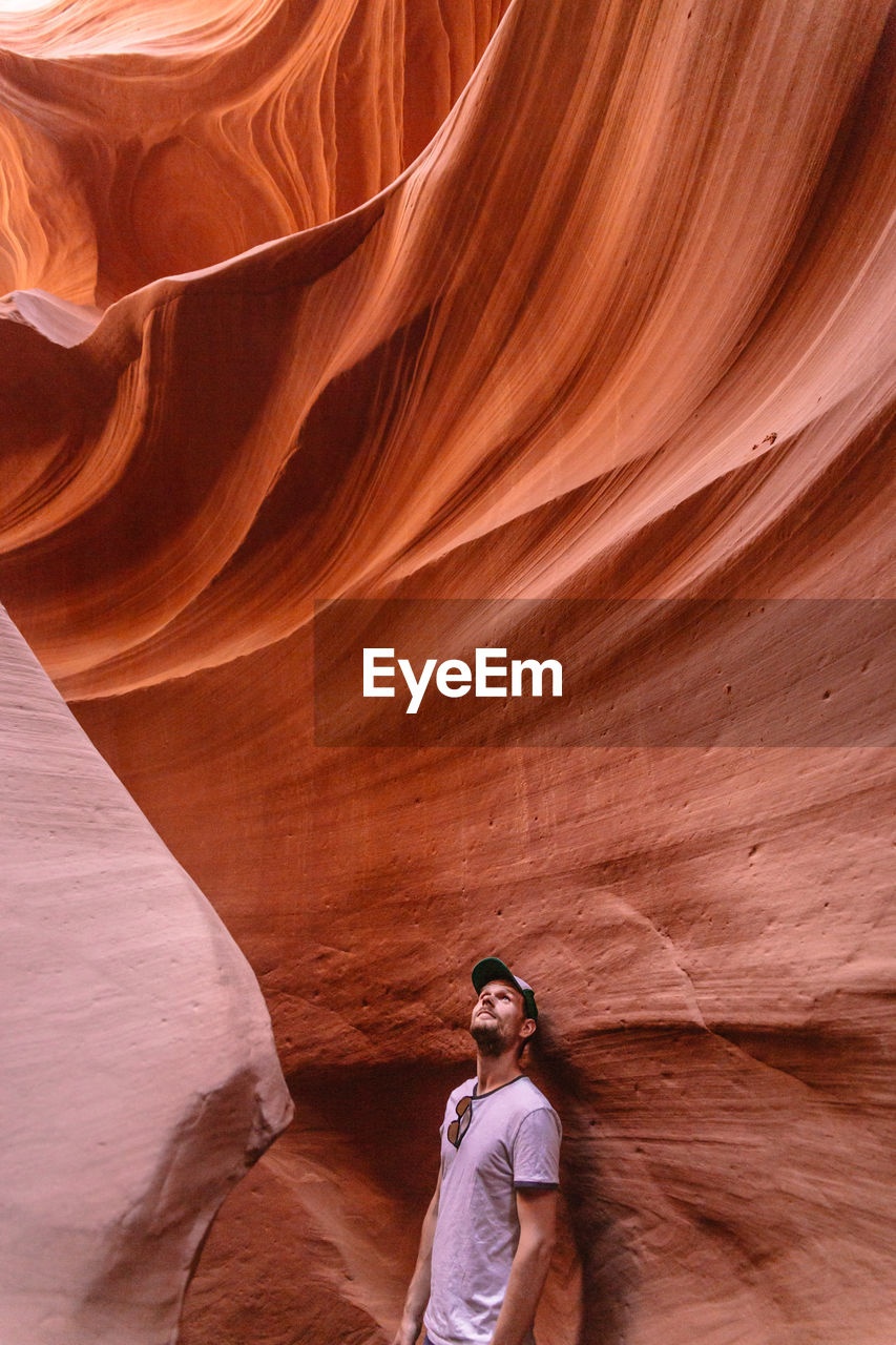 Man standing by rock formation at antelope canyon