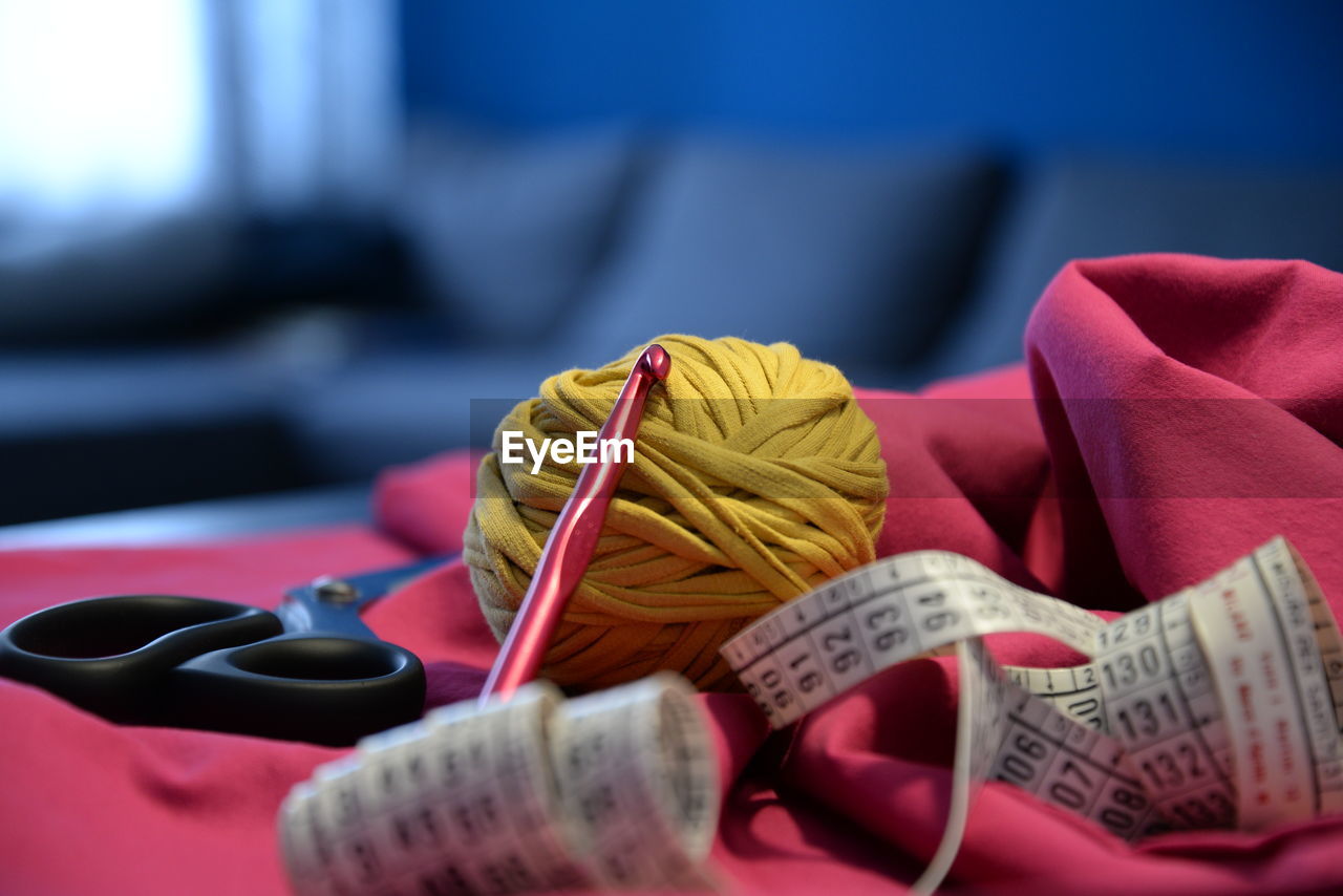 Sewing equipment on table. scissors, ball of yarn sewn, tape and crochet