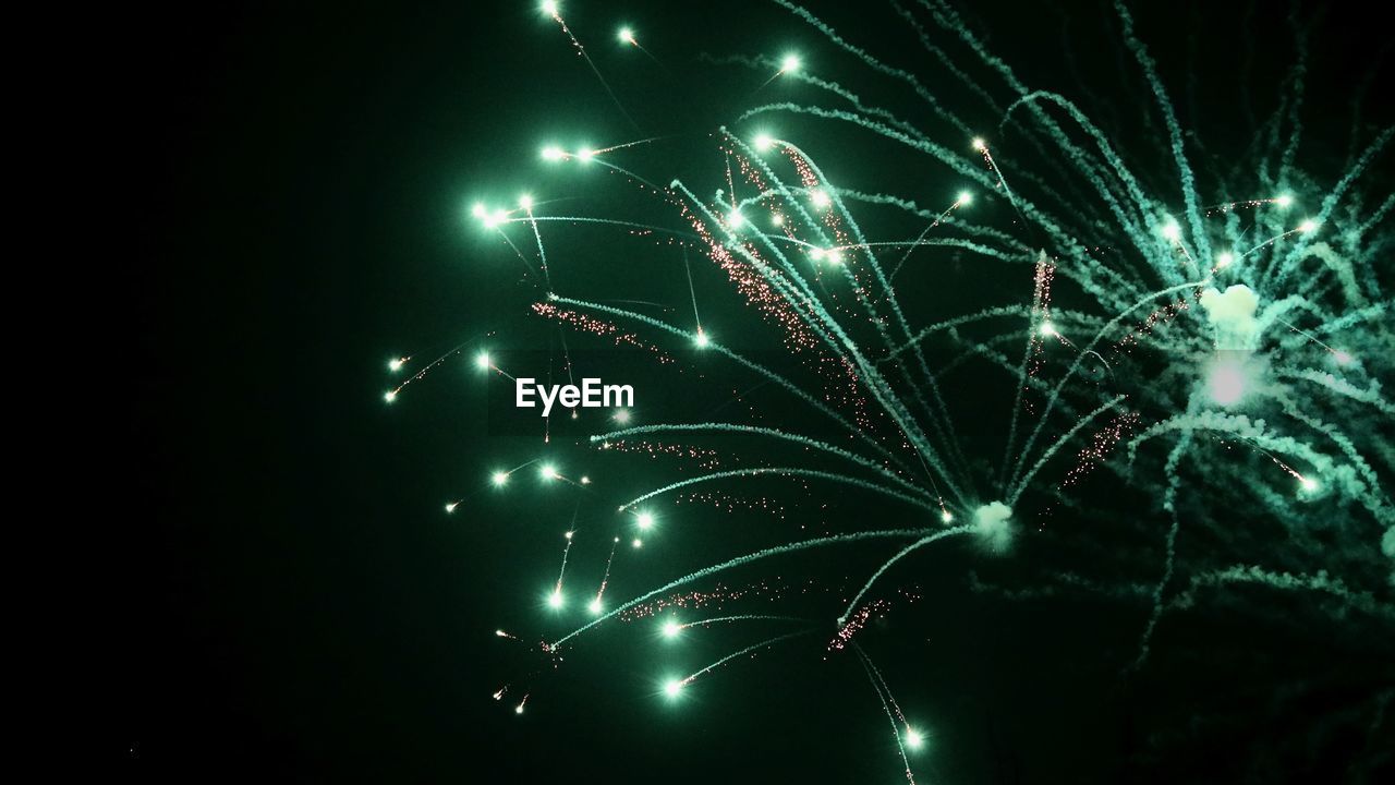 Low angle view of firework display at night