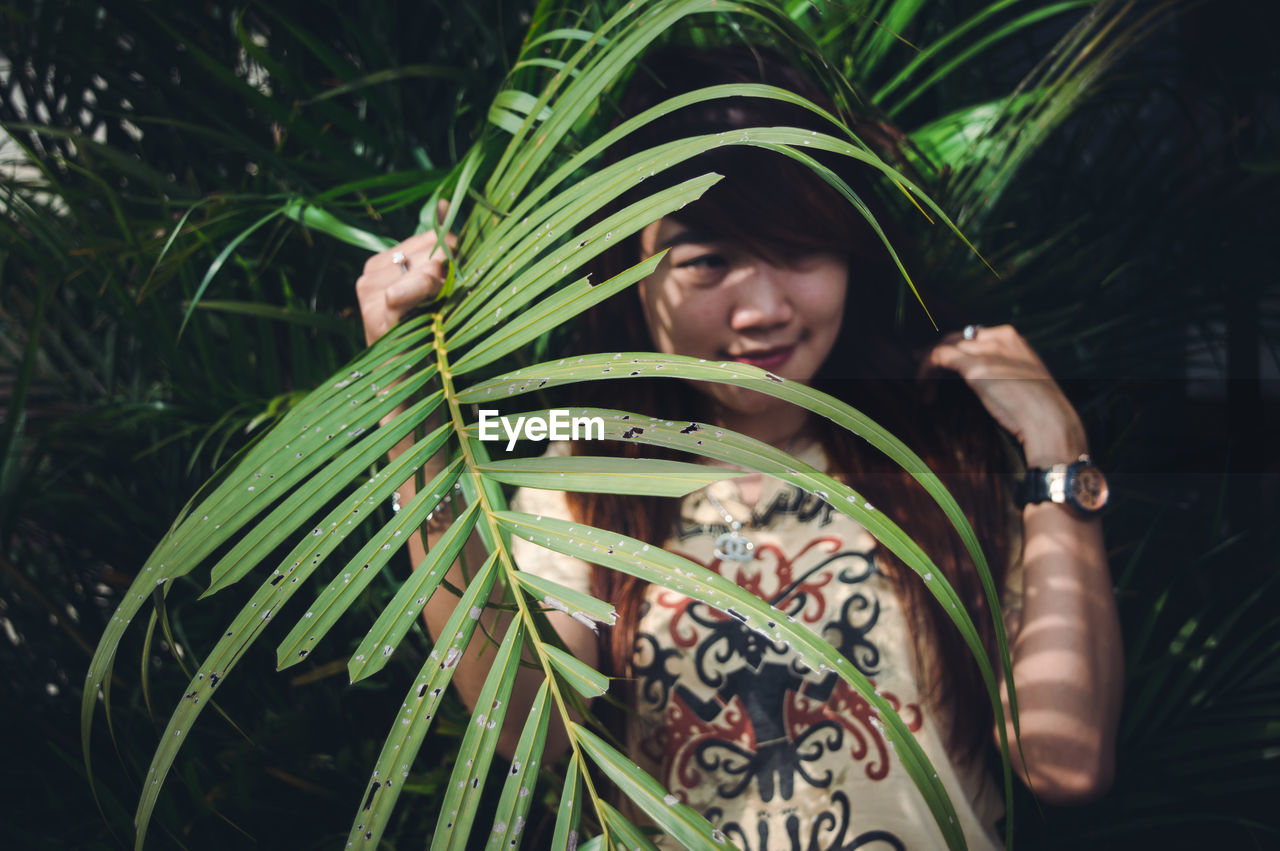 Woman looking away by plants